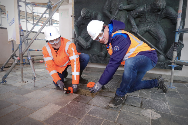 Projectmanager Afsluitdijk Wop Schat en gedeputeerde van Noord Holland Cees Loggen verwijderen de eerste oude tegels. 